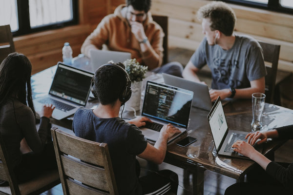 Team of software developers collaborating on laptops
